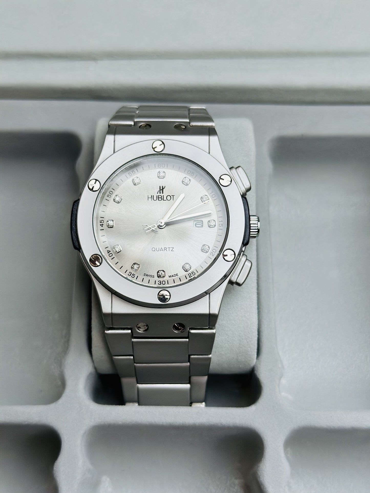 Silver Hublot watch on a gray background
